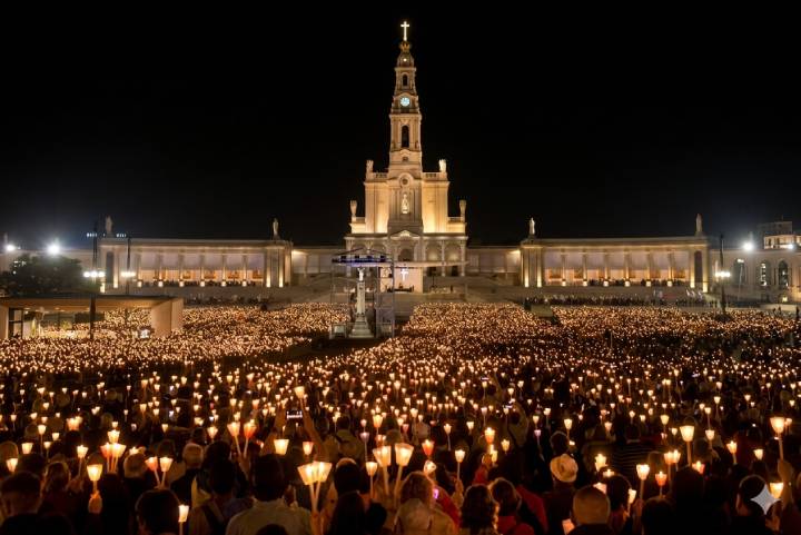 Multitudinaria procesión de las antorchas nocturna en la explanada del Santuario de Fátima, Portugal.